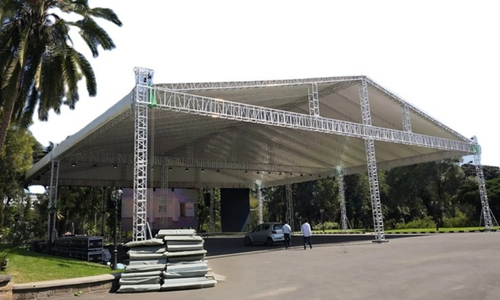 Truss tower system supporting a temporary roof structure for an outdoor event